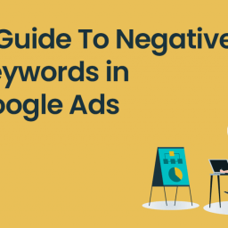 What Are Negative Keywords in Google Ads? 11 A man sitting at a desk, working on a laptop in front of a whiteboard with a graph and a list of items. The background is yellow, and there's a magnifying glass icon and the text "A Guide to Negative Keywords in Google Ads."